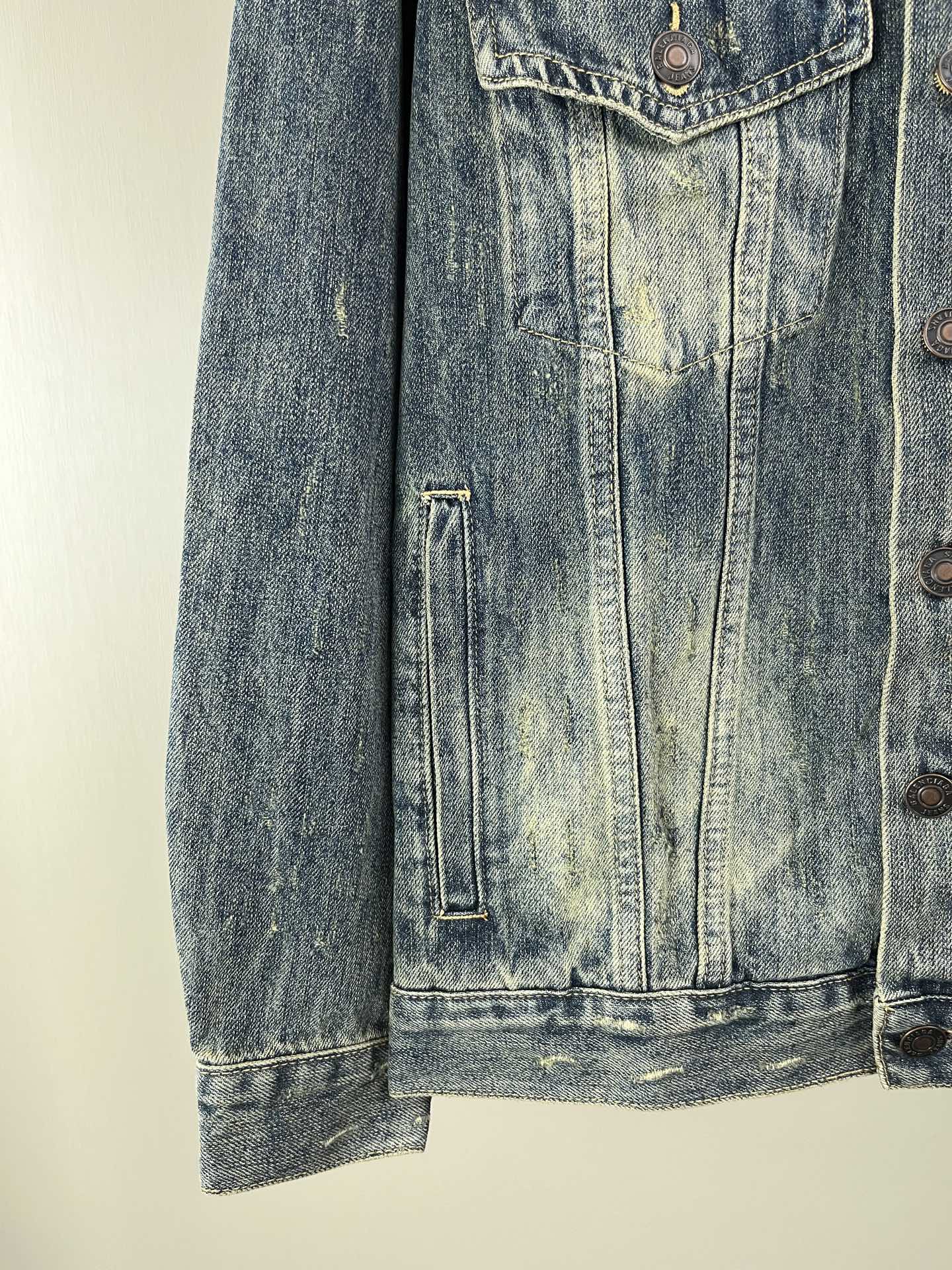 Washed blue denim jacket lower front with vertical flap pocket
