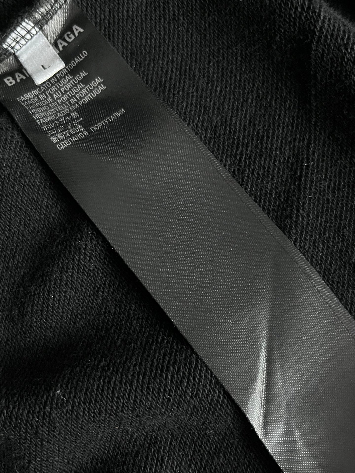 Balenciaga long hoodie interior label tag on dark fabric