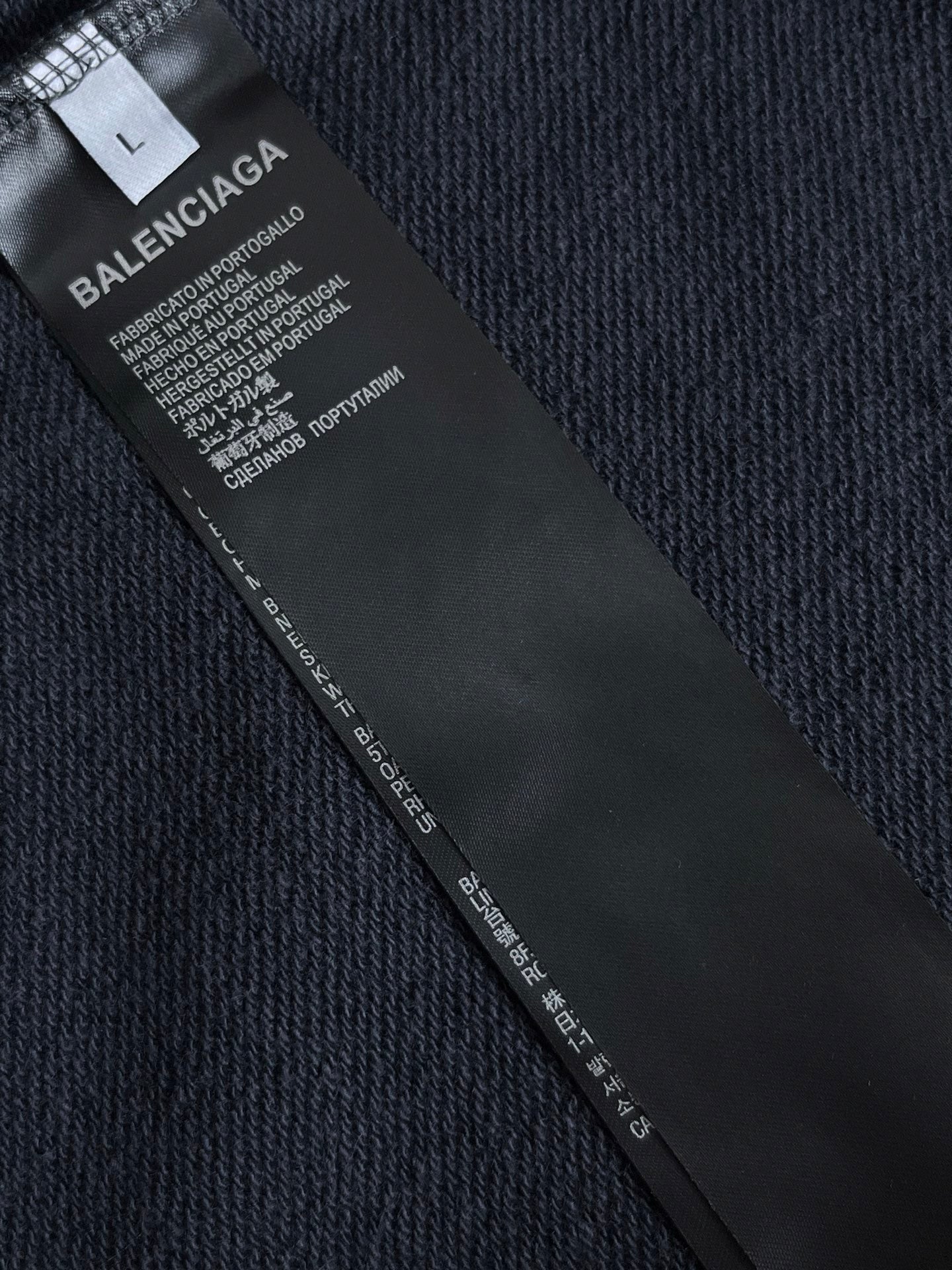 Navy hoodie inside care label with fabric and size information