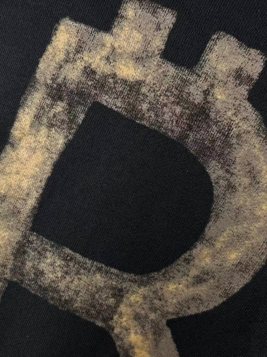 Balenciaga hoodie close-up of distressed letter graphic on dark fabric