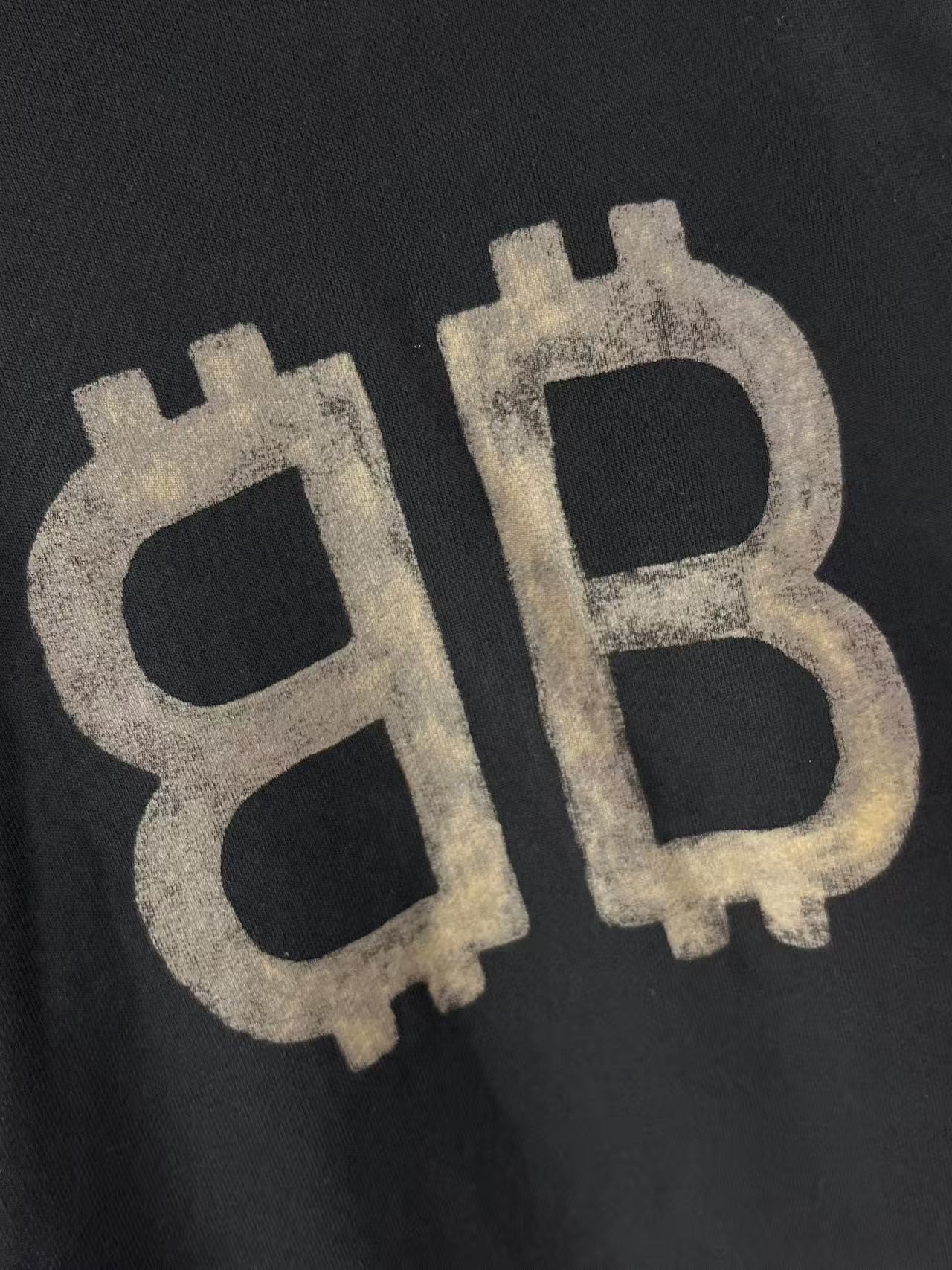 Balenciaga hoodie logo close-up with distressed BB graphic on dark fabric