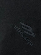 Balenciaga logo patch on dark hoodie fabric, embossed emblem detail
