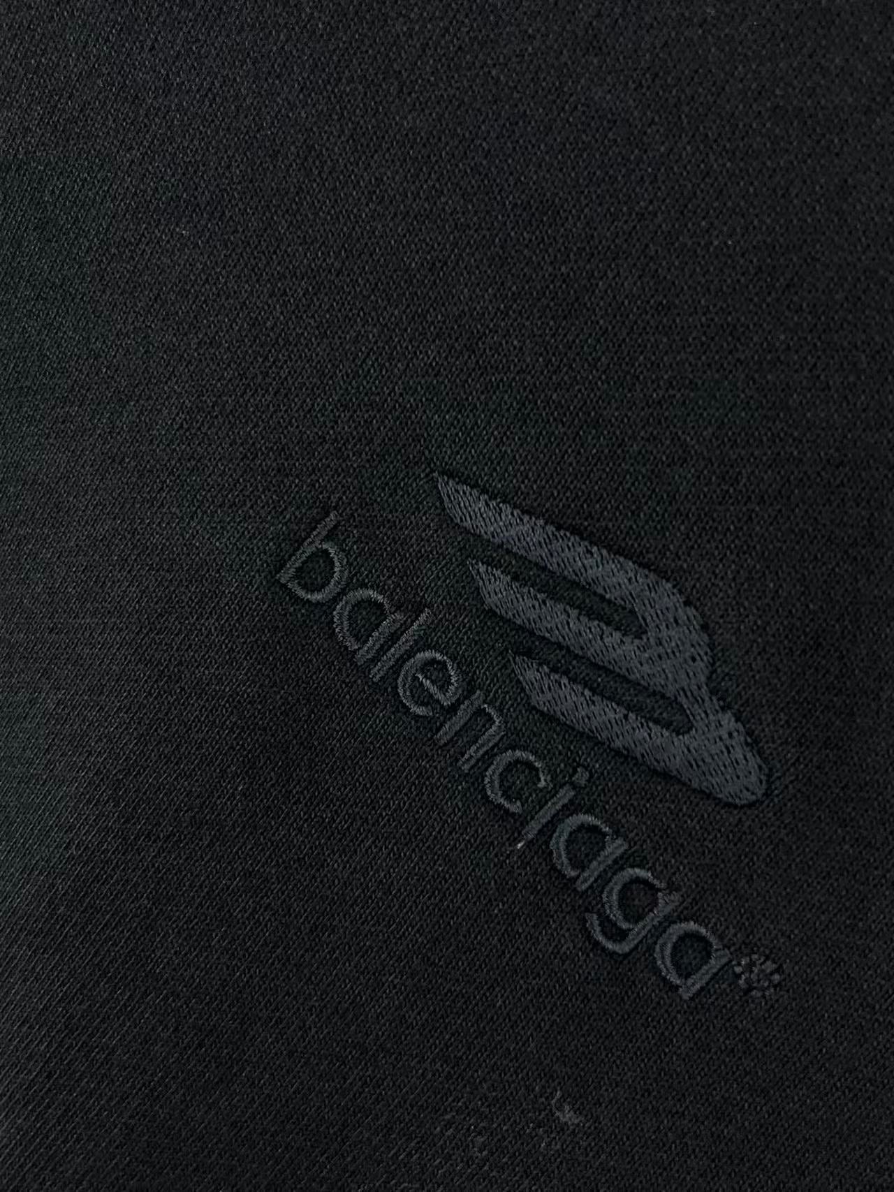 Balenciaga logo patch on dark hoodie fabric, embossed emblem detail