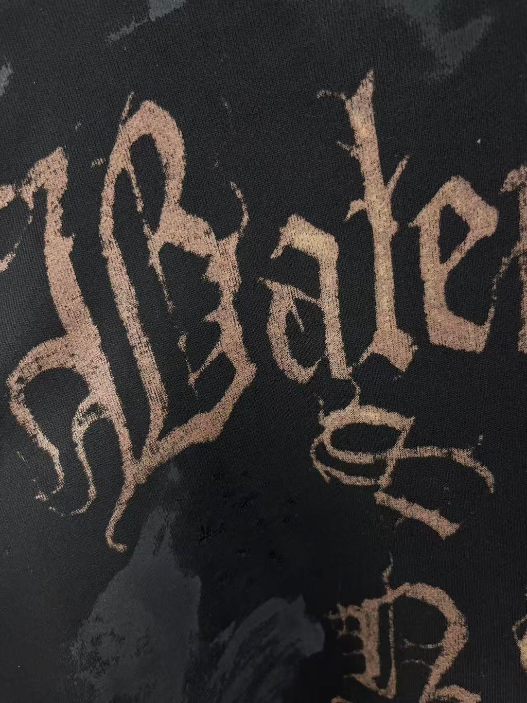 Balenciaga logo print on dark hoodie fabric, close-up of script lettering