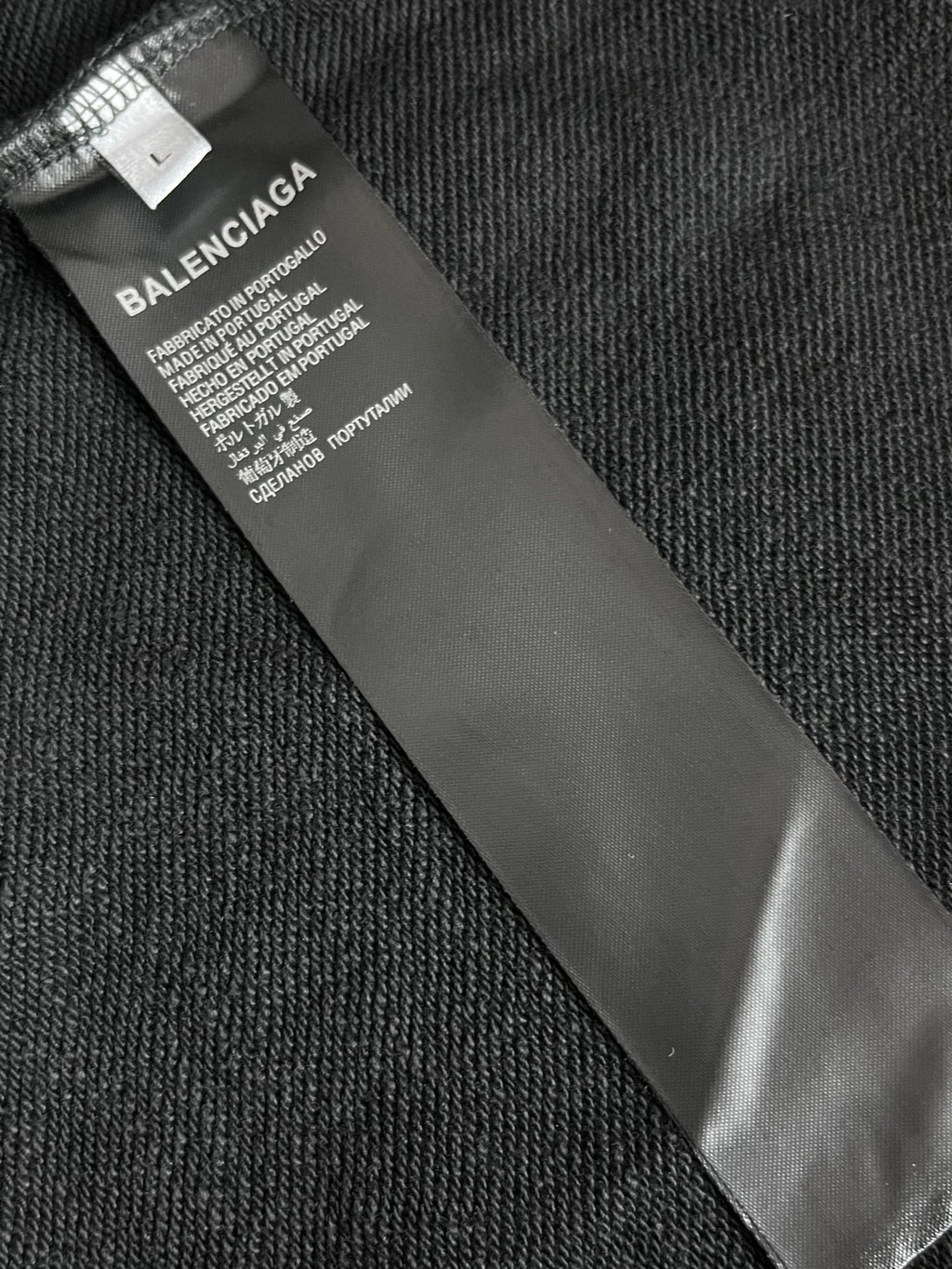Balenciaga size label on inner neck of hoodie, black fabric tag close-up