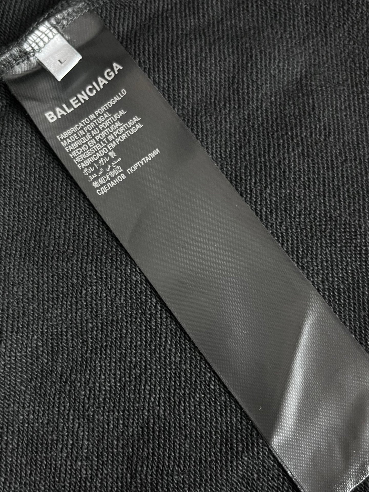 Balenciaga size label on inner neck of hoodie, black fabric tag close-up