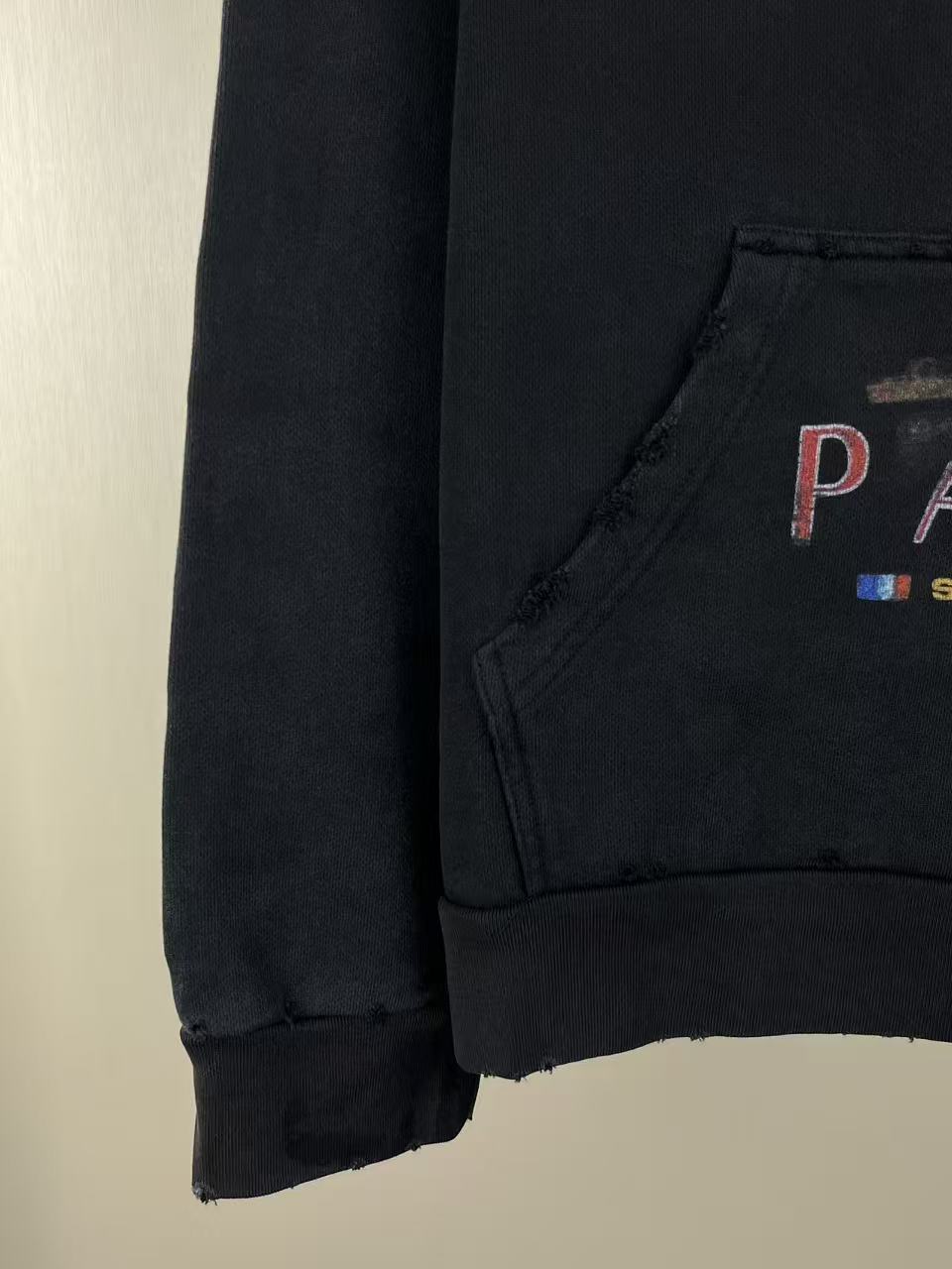Balenciaga dark hoodie sleeve and kangaroo pocket edge detail, distressed hemlike finish