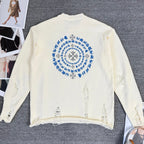 Cream knit sweater with large blue circular embroidery on back