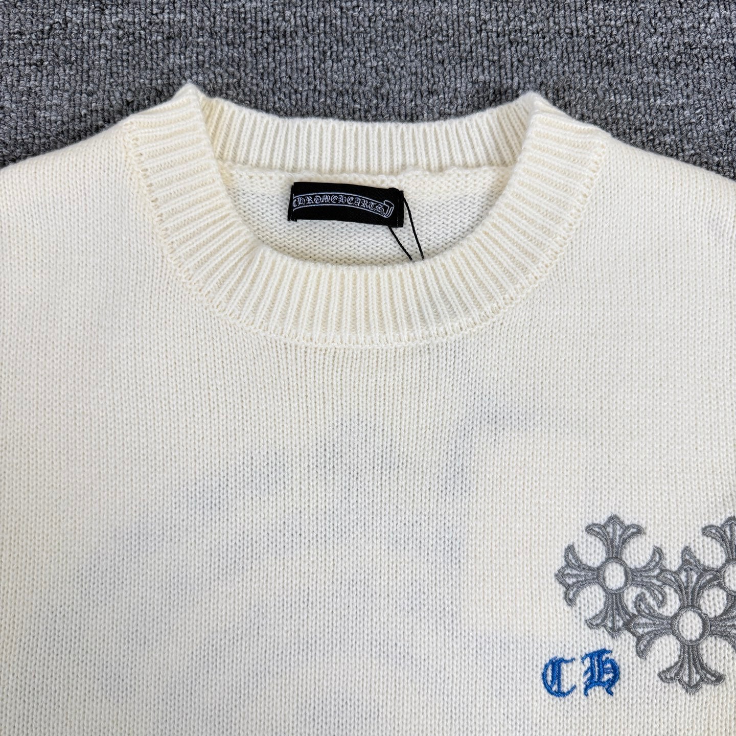 Cream knit sweater neckline with ribbed collar and brand label