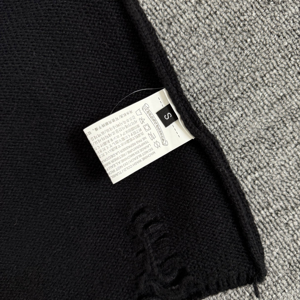 Long-sleeve sweater neck label tag on black knit