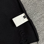 Long-sleeve sweater neck label tag on black knit