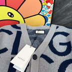 Kids cardigan neckline close-up, light gray knit with navy Gucci pattern and buttons
