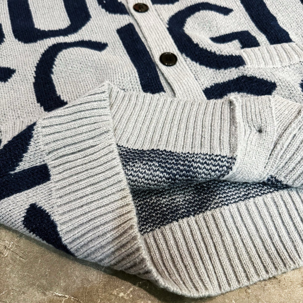 Kids cardigan hem close-up, light gray ribbed knit with navy Gucci-style stripe