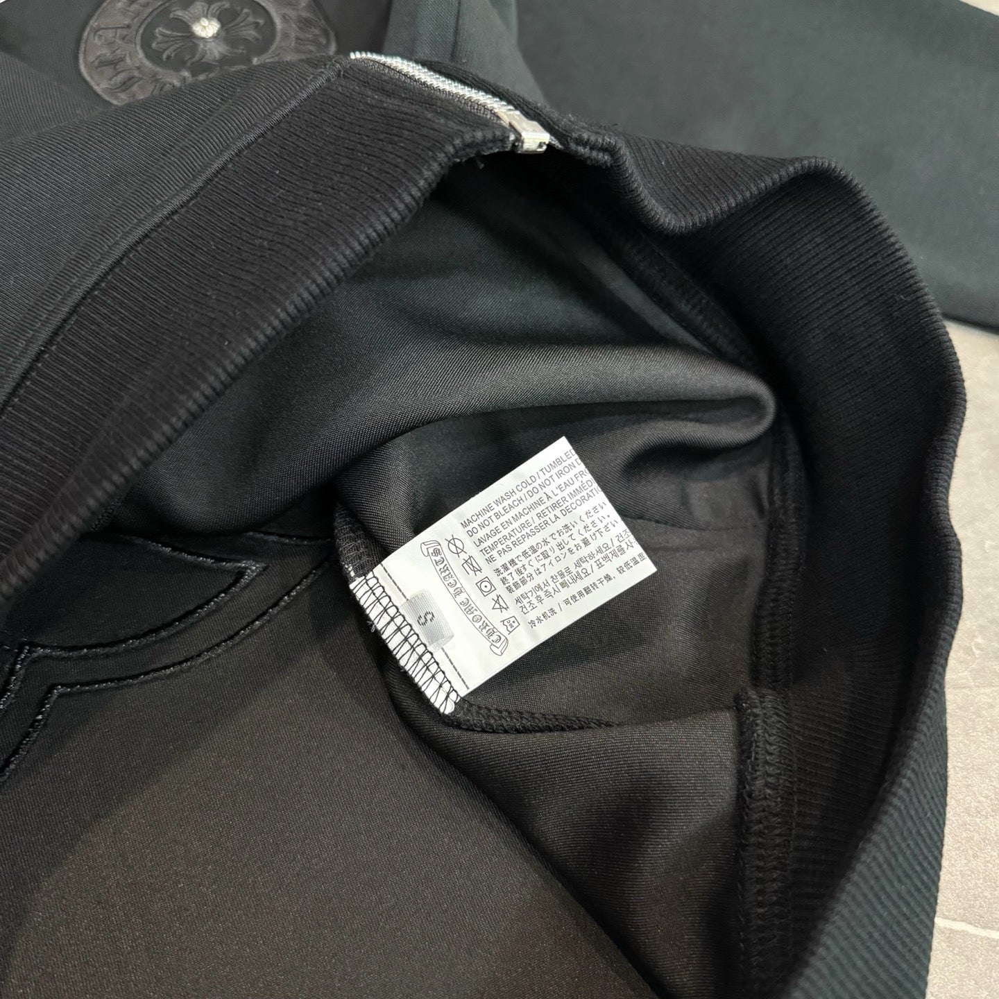 Black hoodie fabric close-up with interior care label on the collar