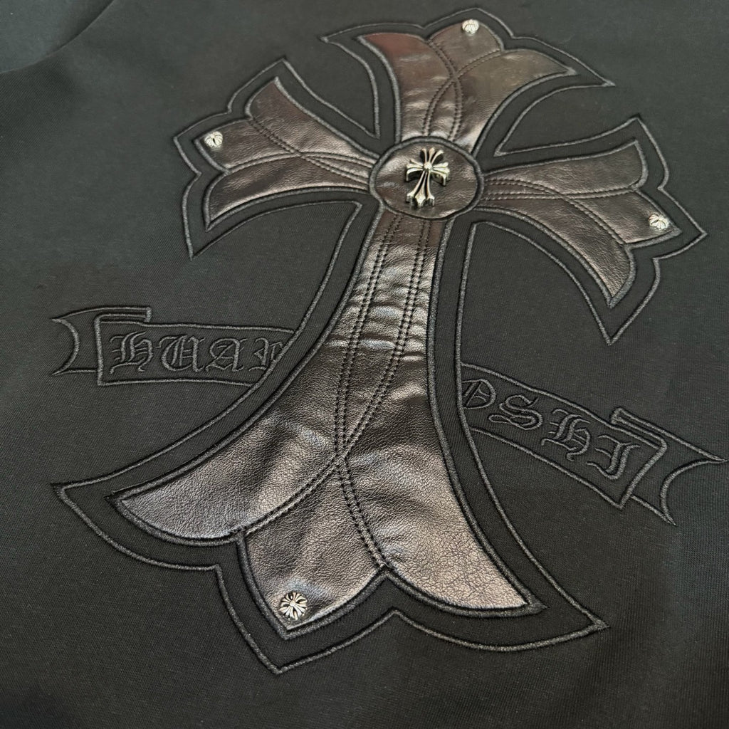 Black hoodie close-up of bow emblem with ribbon-style embroidered text