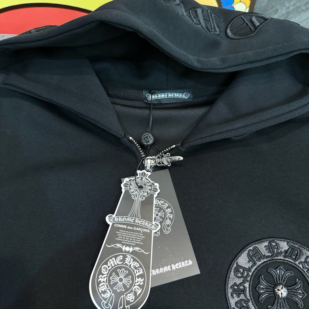 Black hoodie neckline with zipper pull and hanging charm tag under the hood