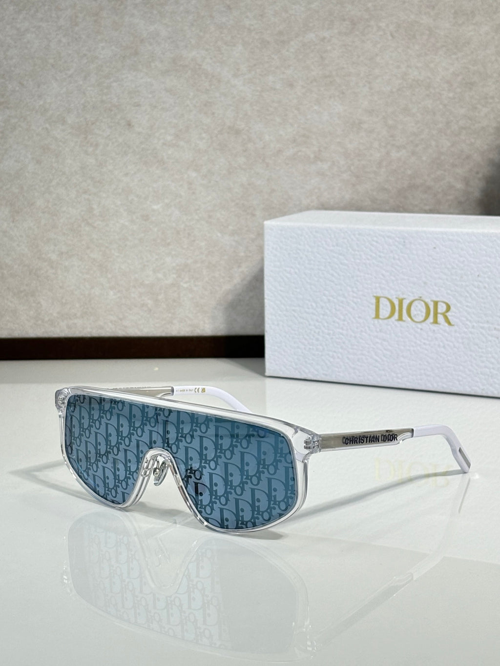 Dior sunglasses with clear frame and blue patterned tinted lenses