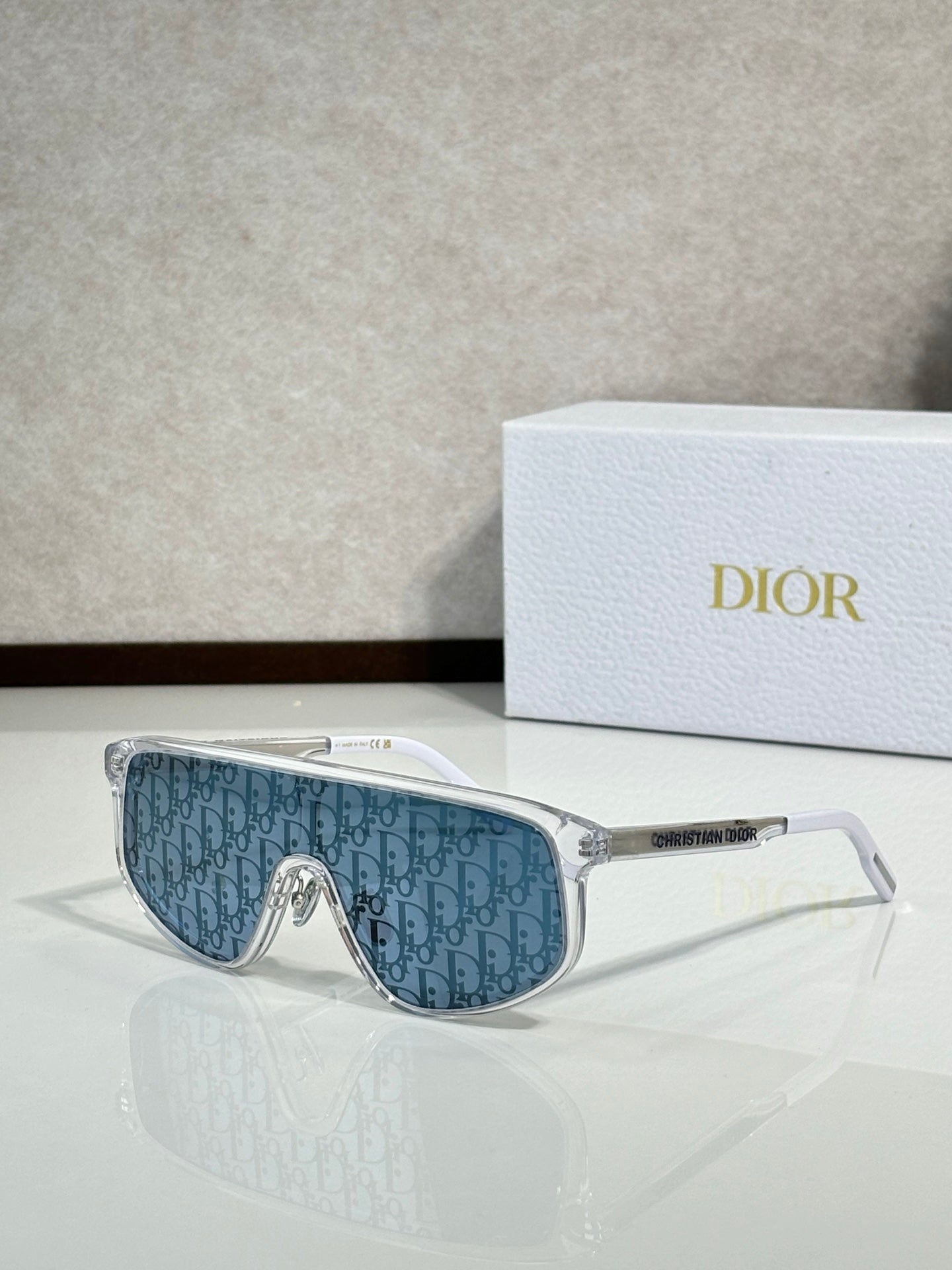 Dior sunglasses with clear frame and blue patterned tinted lenses