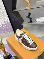 Louis Vuitton monogram sneakers with white laces and character charm detail.