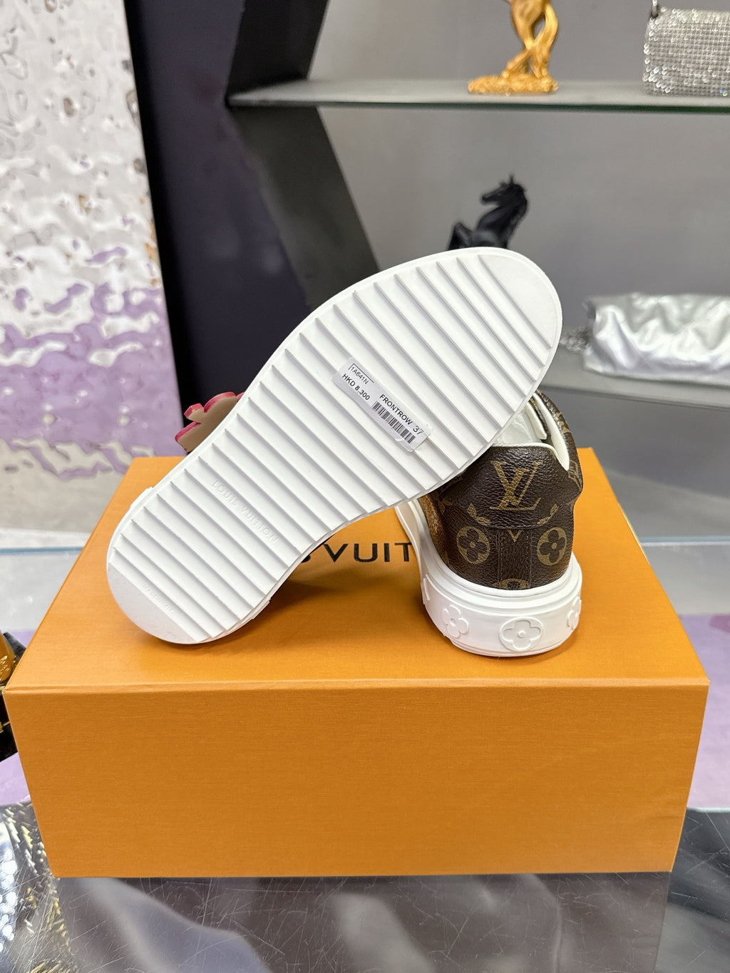 Louis Vuitton monogram sneakers with textured white outsole, side view.