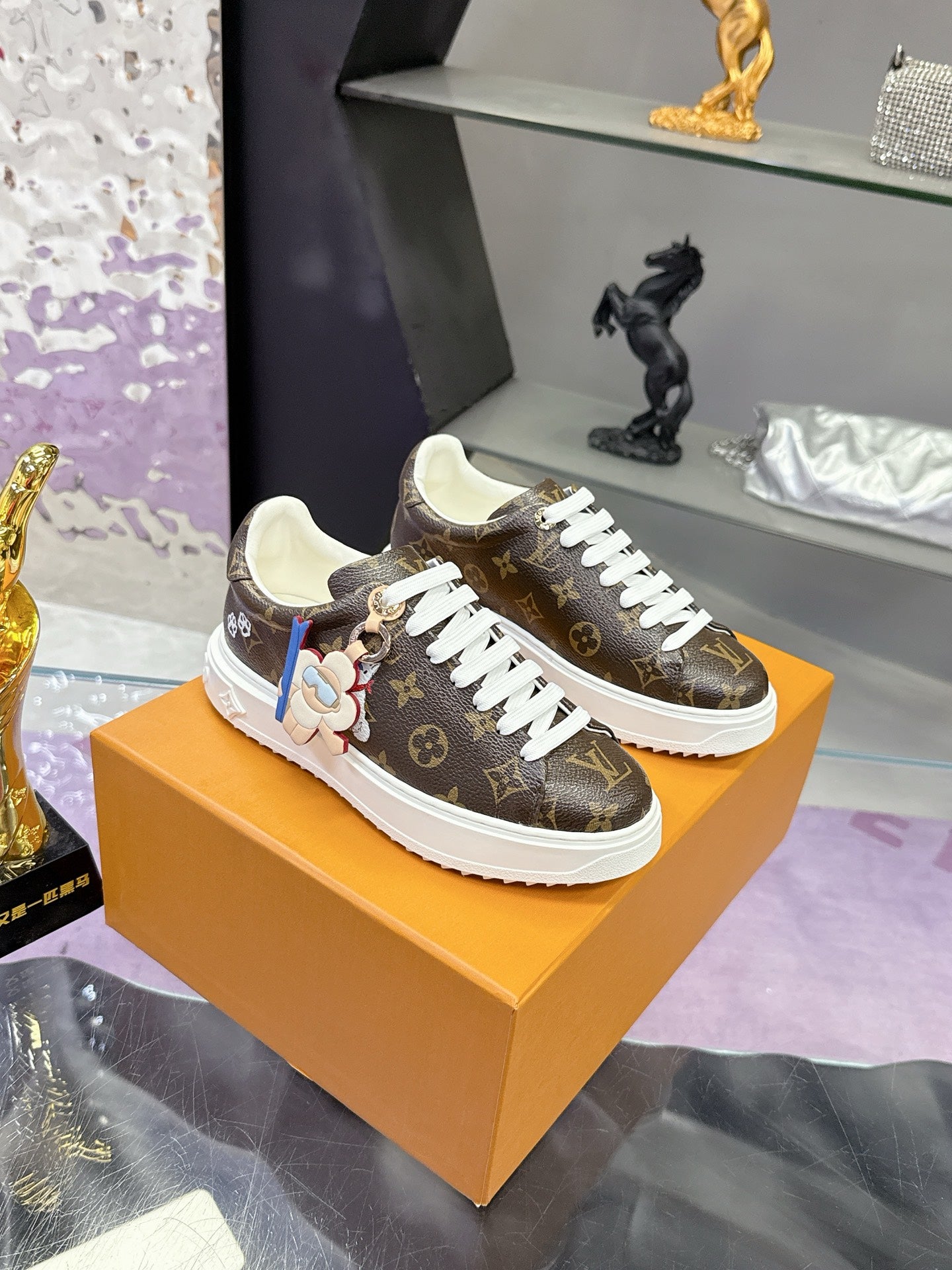 Louis Vuitton monogram low-top sneakers with white laces.