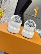 White Louis Vuitton sneakers, rear view with metallic heel badge and molded sole tread