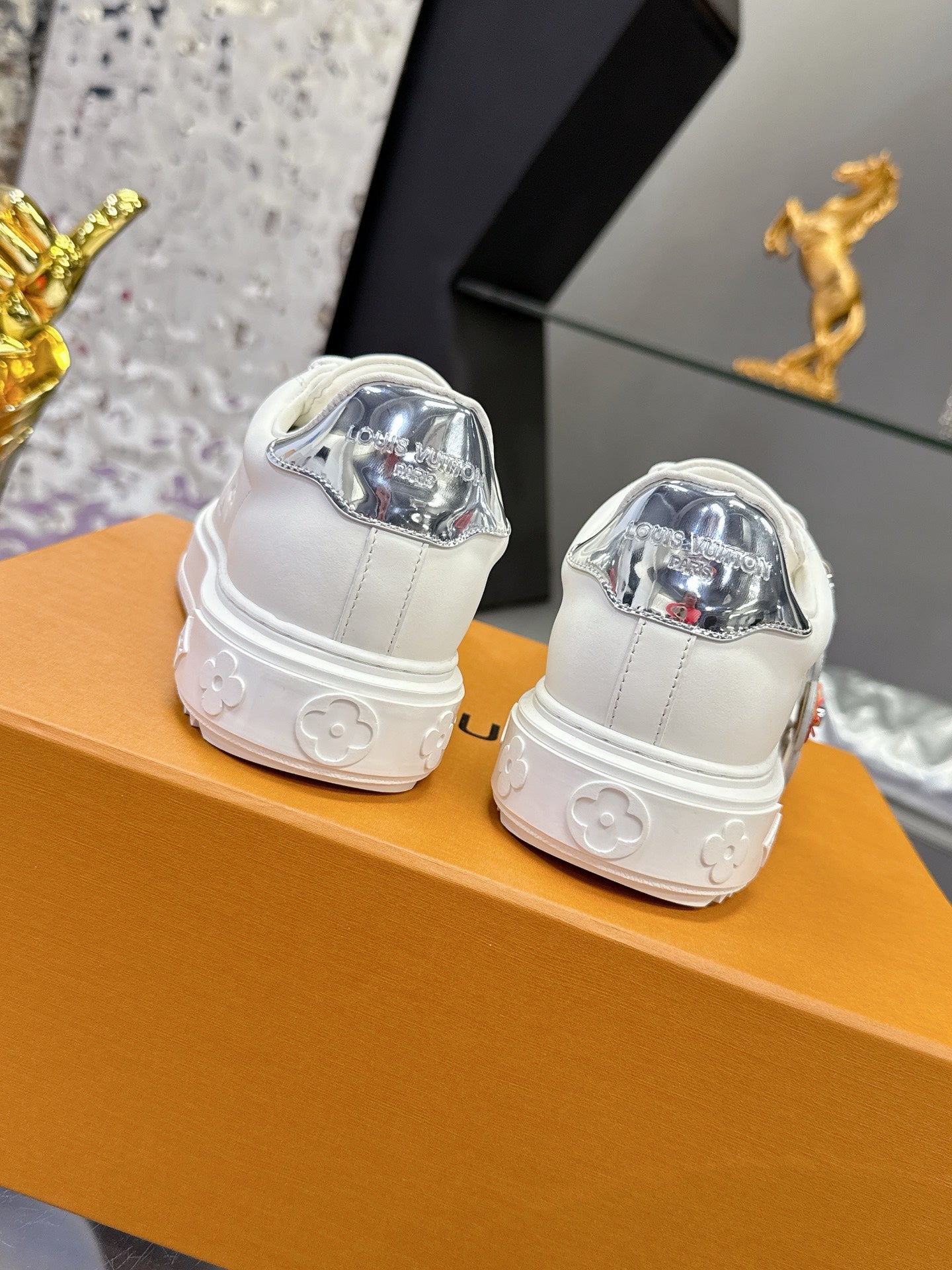 White Louis Vuitton sneakers, rear view with metallic heel badge and molded sole tread