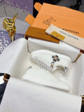White Louis Vuitton low-top sneakers with lace-up front and decorative charm detail