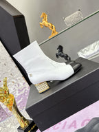 White mid-calf ankle boots with black toe caps and gold jeweled block heel