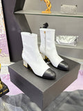 White mid-calf heeled boots with black toe caps and jeweled gold block heels