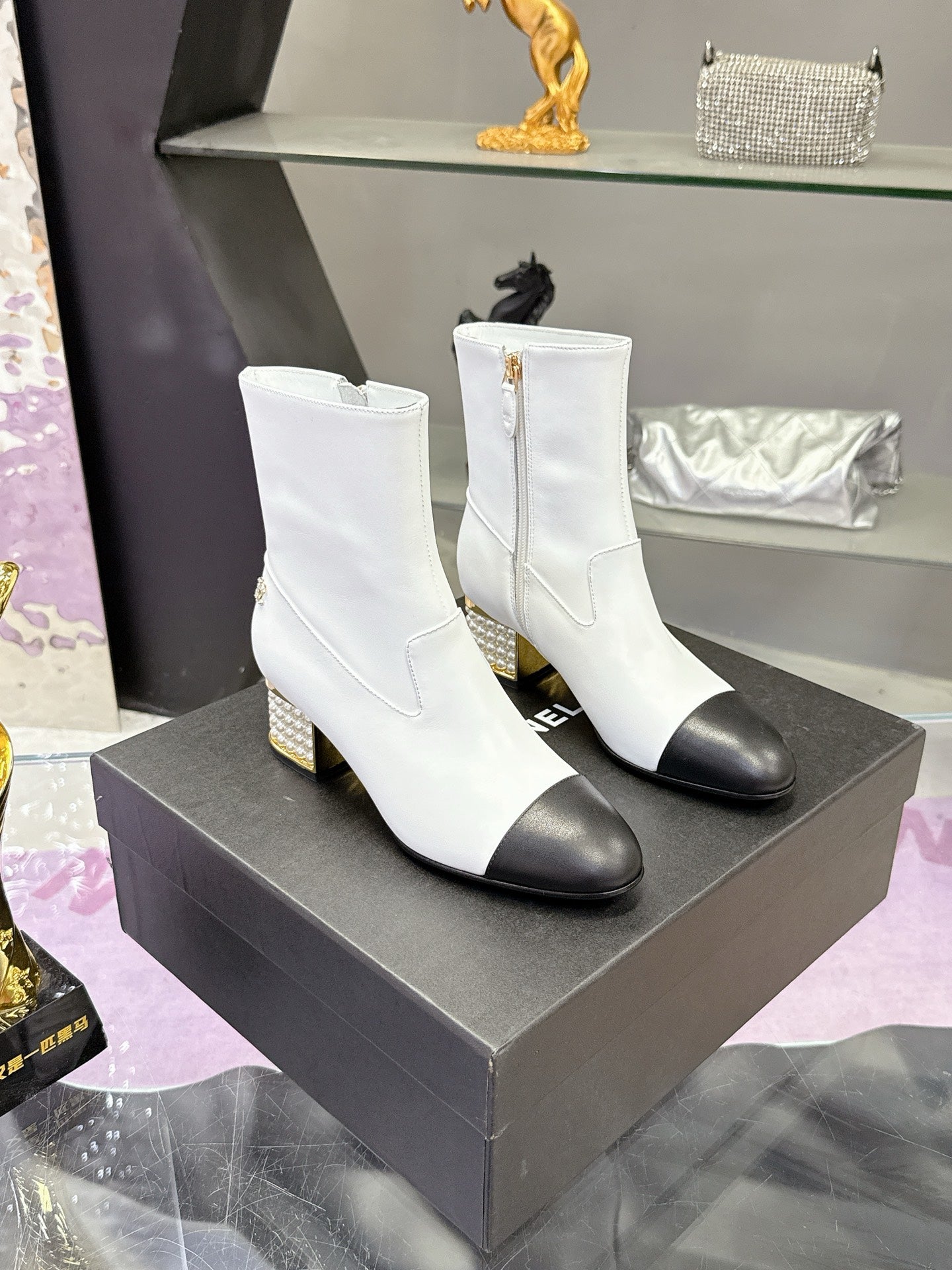 White mid-calf heeled boots with black toe caps and jeweled gold block heels