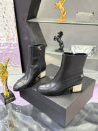 Pair of black leather ankle boots with jeweled block heels and side logos