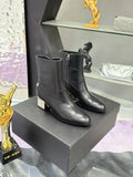 Black leather ankle boots with block heels, gold logo detail at side