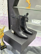 Black leather ankle boots with block heels, gold logo detail at side