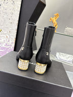 Black leather ankle boots with jeweled gold block heels and side emblem
