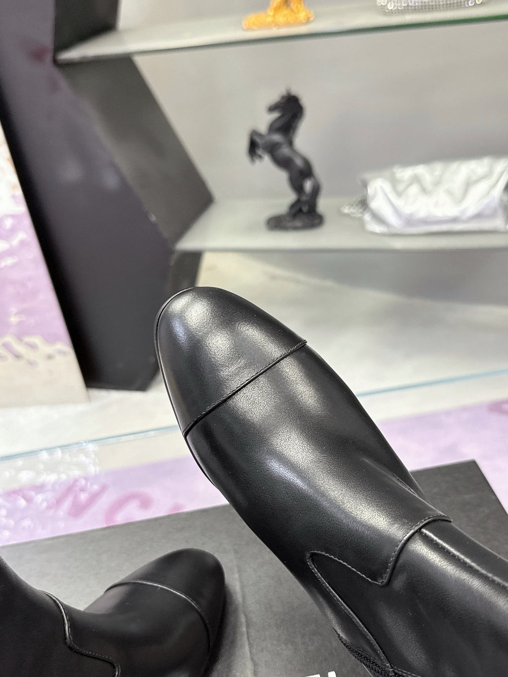 Close-up of black leather ankle boots with smooth vamp and stitched seams
