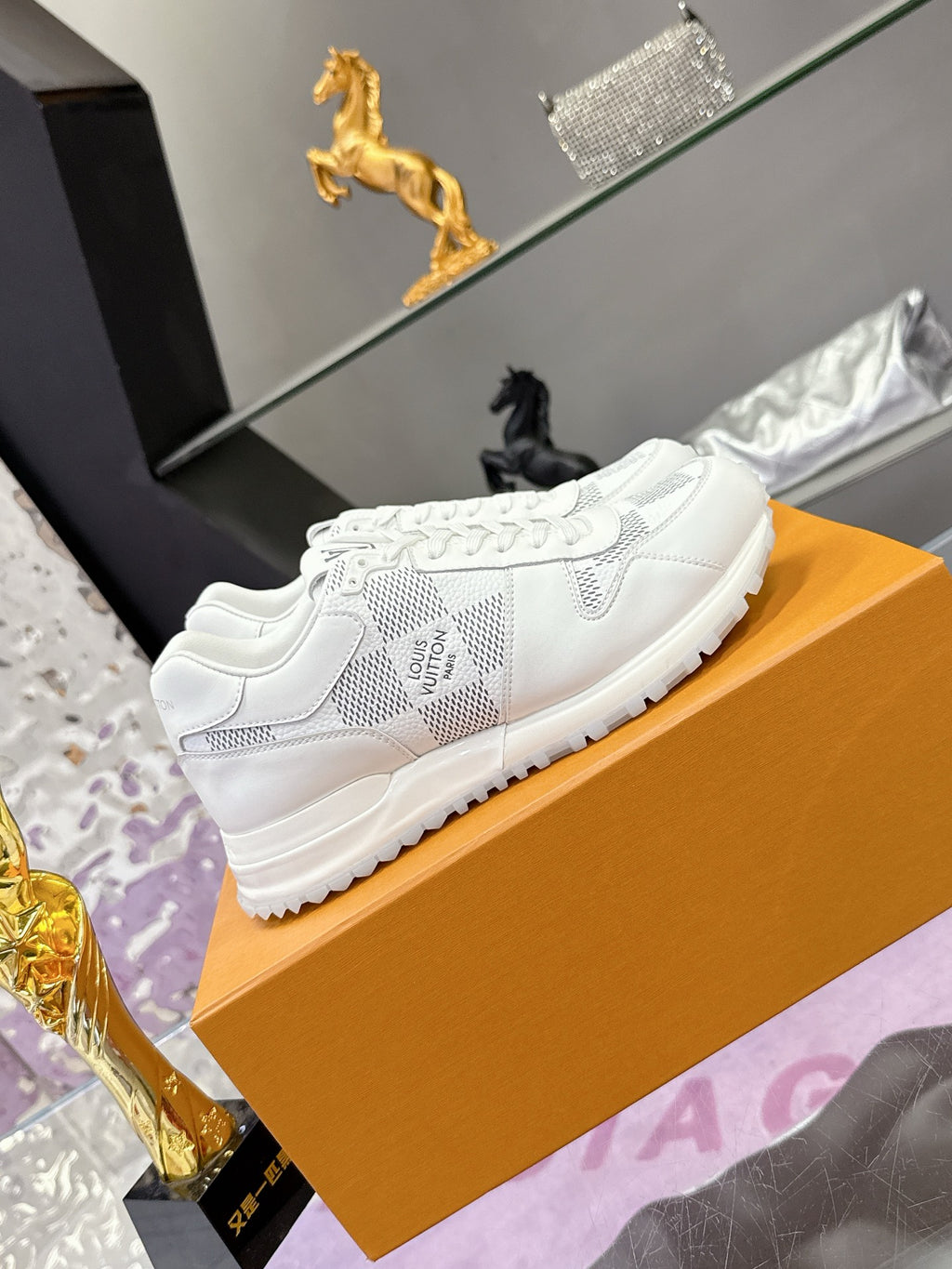 Louis Vuitton white lace-up sneakers with Damier-style logo print, side view
