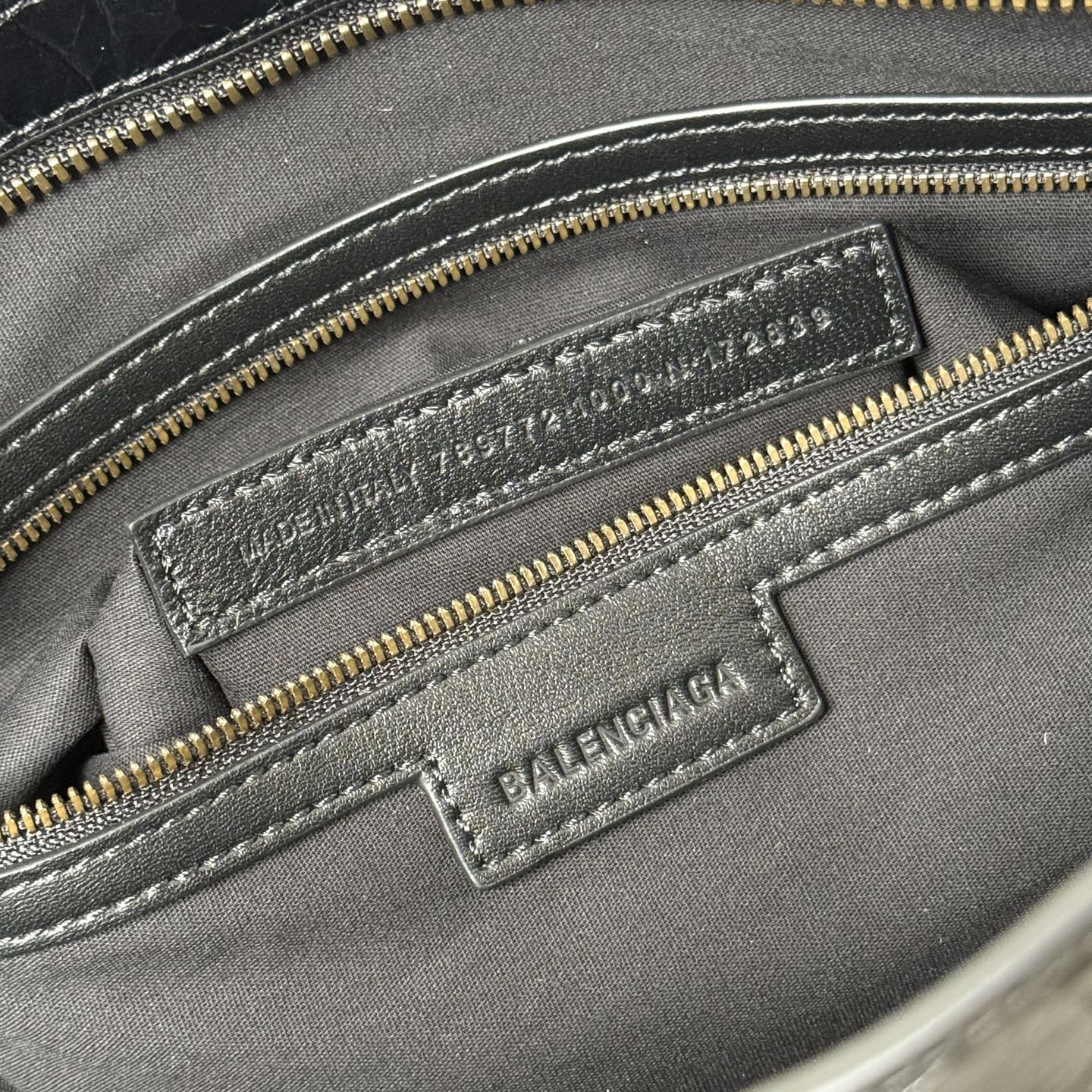 Balenciaga embossed leather logo patch on interior pocket with gold zipper trim