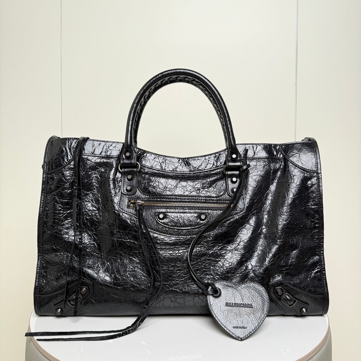 Balenciaga black leather tote bag with top handles and front zipper pocket plus heart charm