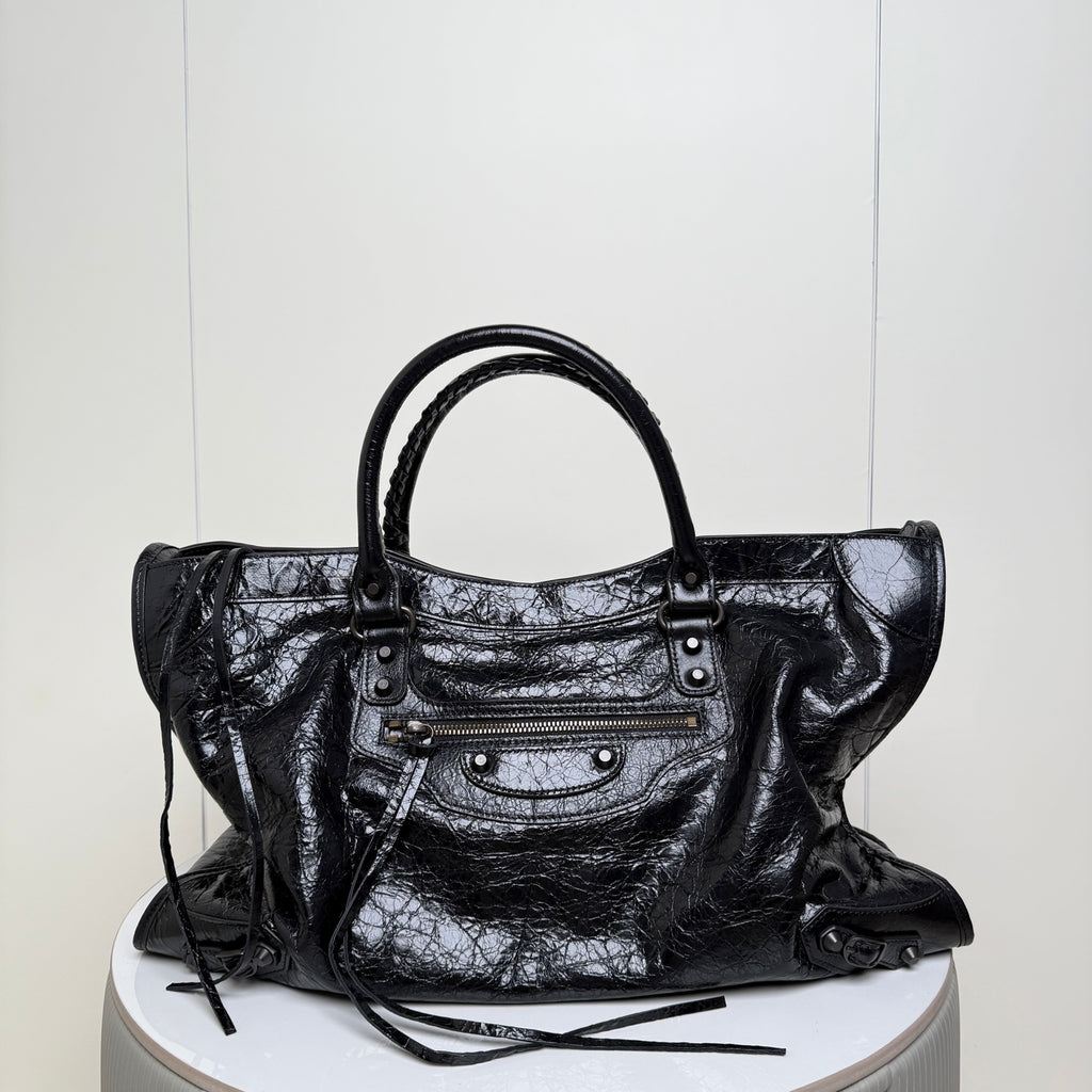 Balenciaga black leather tote bag with top handles and front zipper pocket with metal studs