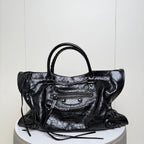 Balenciaga black leather tote bag with top handles and front zipper pocket with metal studs