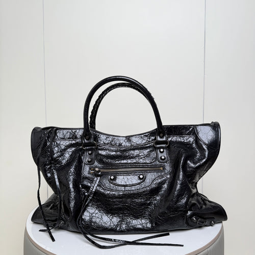 Balenciaga black leather tote bag with top handles and front zipper pocket with metal studs