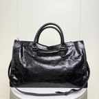 Balenciaga black leather tote bag with top handles and front strap details with buckles