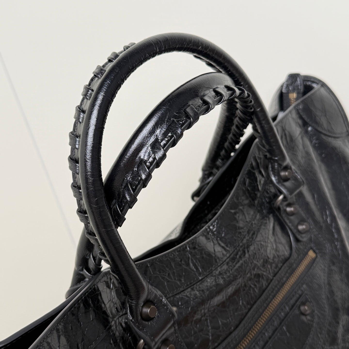 Balenciaga black leather tote bag handle with braided strap and metal eyelet hardware