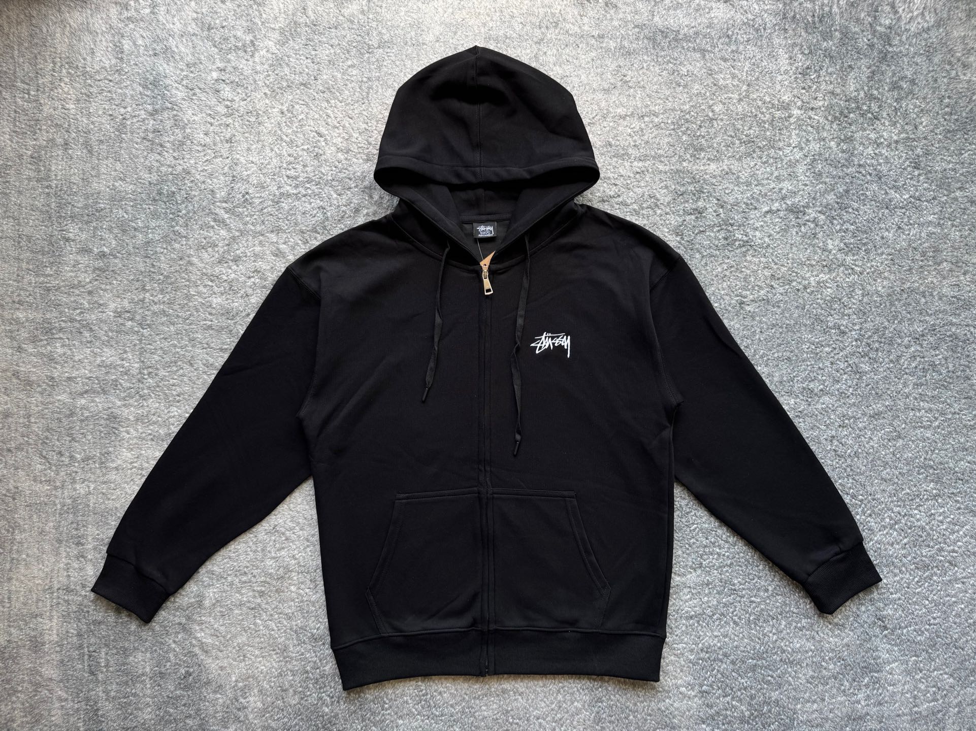 Stussy black zip-up hoodie front with drawstring hood and chest logo