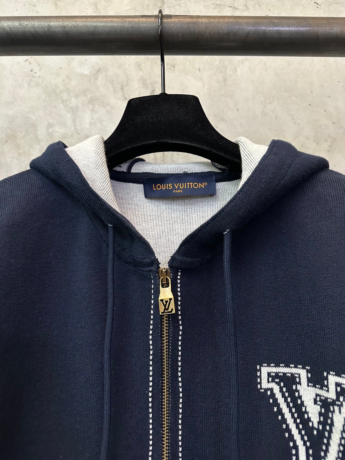 Navy Louis Vuitton zip-up hoodie neckline with gold zipper pull and LV lettering