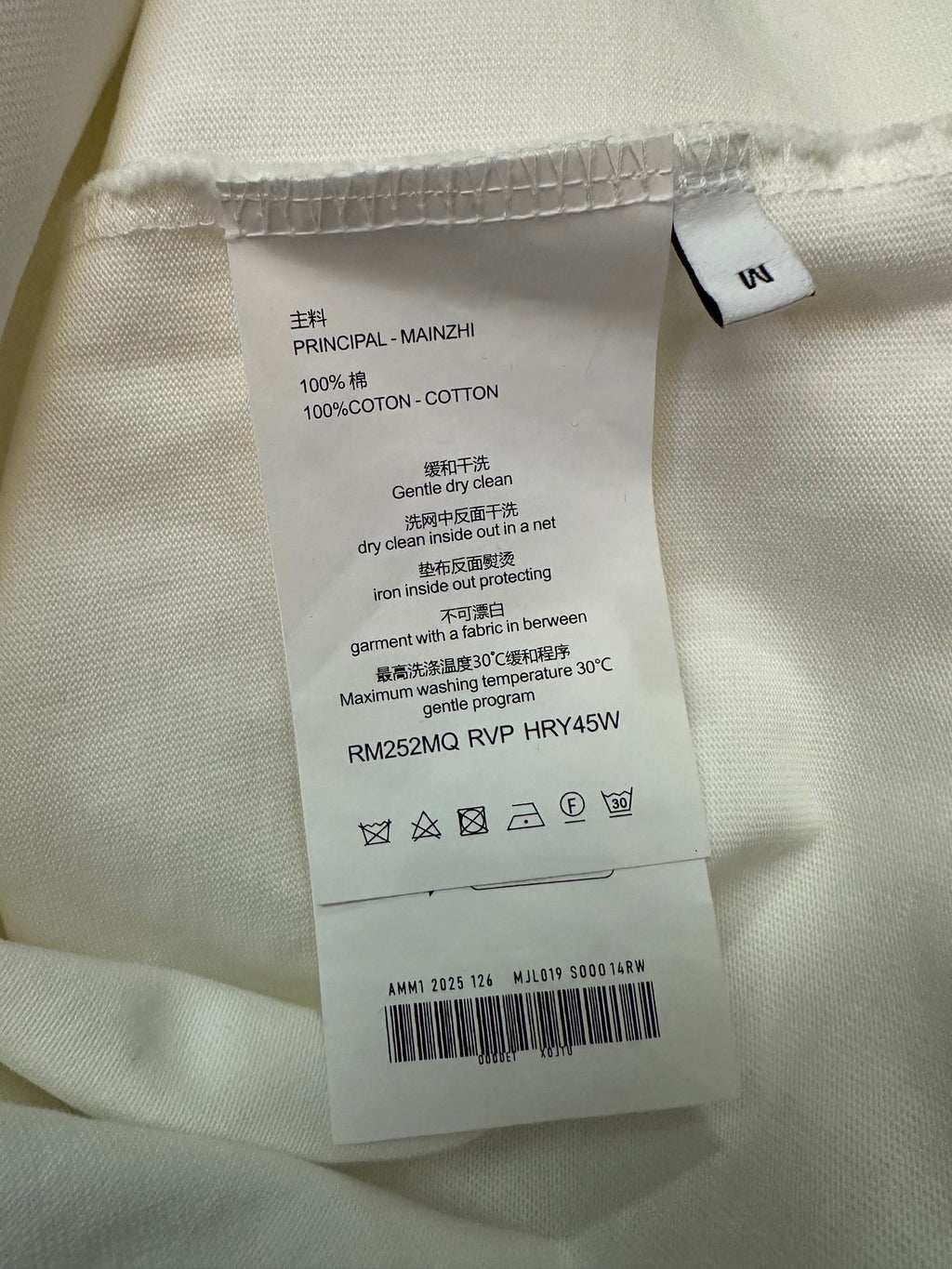 White T-shirt care label: 100% cotton, dry clean details, Germany text