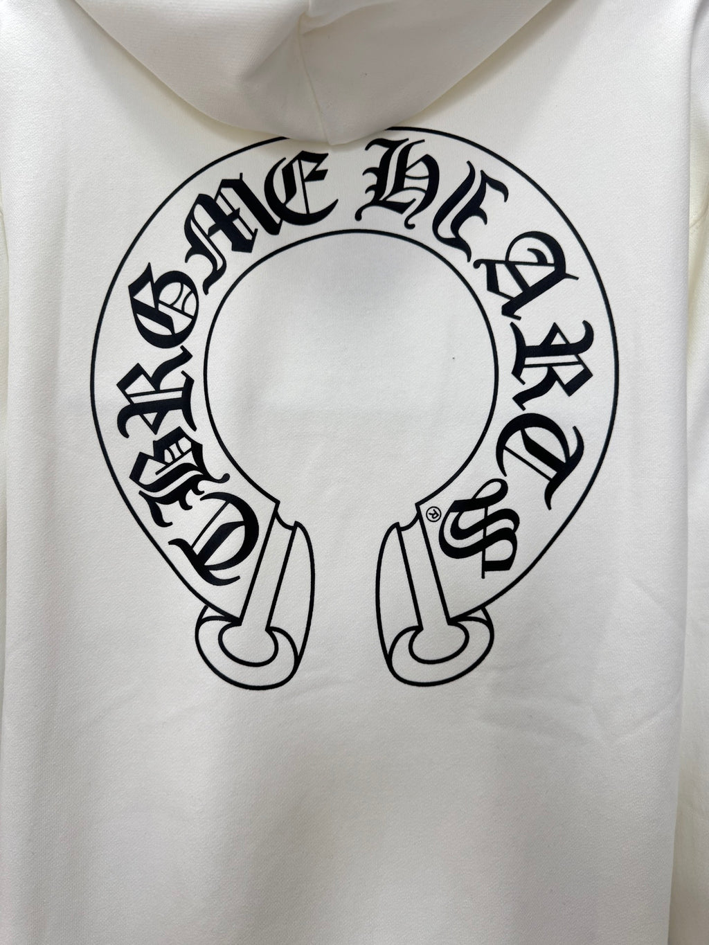 White hoodie close-up of large circular logo graphic on the front