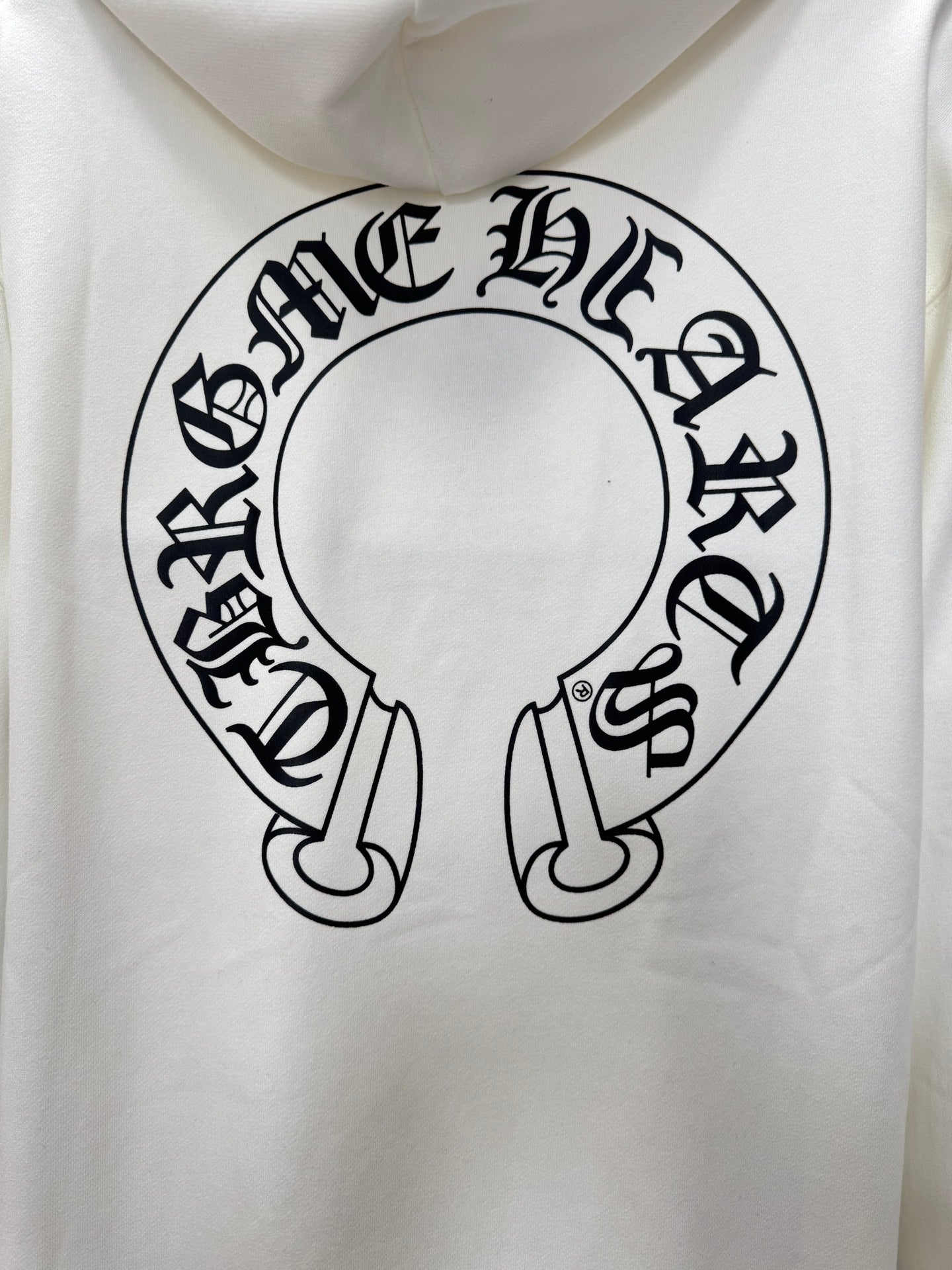 White hoodie close-up of large circular logo graphic on the front