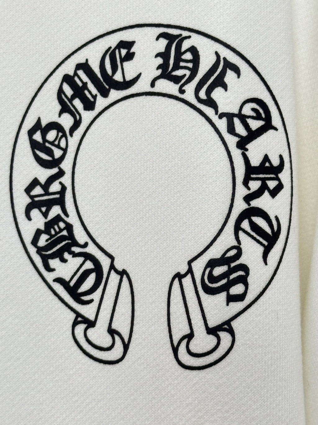 White hoodie fabric close-up of large circular graphic logo in black